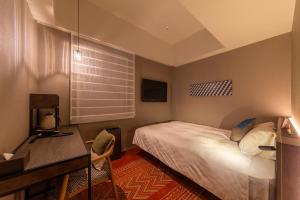 Schlafzimmer mit einem Bett, einem Schreibtisch und einem Fenster in der Unterkunft Royal Park Hotel Kurashiki in Kurashiki