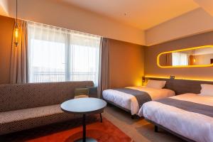 سرير أو أسرّة في غرفة في Royal Park Hotel Kurashiki