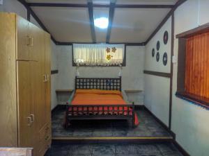 a small bedroom with a bed in a room at La Casita Alquiler Temporario in Merlo