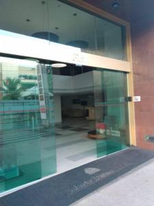 une porte en verre d'un bâtiment avec un couloir dans l'établissement Salvador Business & Flat propriedade, à Salvador
