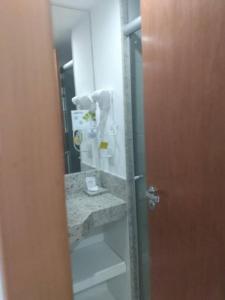 a bathroom with a mirror and a sink and a toilet at Salvador Business & Flat propriedade in Salvador