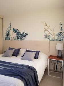 Schlafzimmer mit einem Bett mit blauen und weißen Kissen in der Unterkunft Terra Departamentos Boutique in La Falda