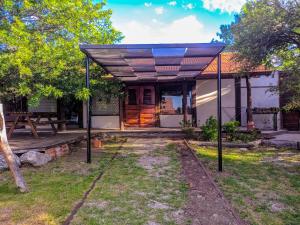 a pavilion with a table and a bench in a yard at La Casita Alquiler Temporario in Merlo