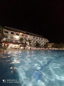 een groot zwembad voor een hotel 's nachts bij Laguna Beach Flat in Porto De Galinhas