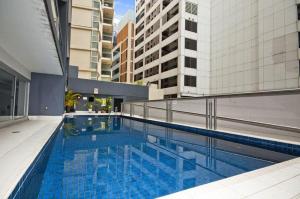 a large swimming pool in a city with buildings at A Cozy & Spacious Apt for 6 Next to Darling Harbour in Sydney