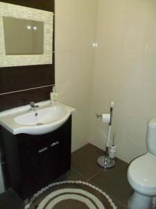 a bathroom with a sink and a toilet and a mirror at Residencial Ponto Certo in Vilar Torpim