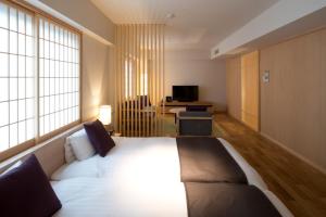 a bedroom with a large bed in a room with windows at Takamatsu Kokusai Hotel in Takamatsu