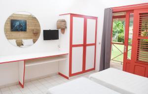 Cette chambre comprend un miroir et une porte rouge. dans l'établissement Imperatrice Village - Résidence sur la plage, à Les Trois-Îlets