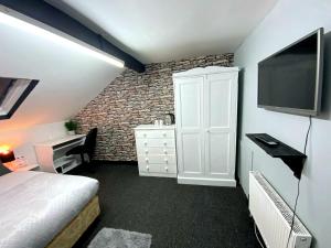 um quarto com uma cama e uma televisão na parede em Townhouse 105 em Huddersfield