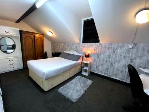 a bedroom with a bed and a sink and a mirror at Townhouse 105 in Huddersfield