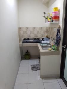 een kleine keuken met een wastafel en een fornuis bij Aloha Guest House 2 - Female Only in Tangerang