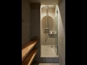 a bathroom with a shower with a wooden tub at Do-C Gotanda in Tokyo