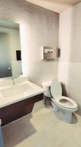 a bathroom with a toilet and a sink and a tub at Garden Executive Hotel in South Plainfield