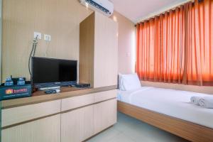 une chambre d'hôtel avec deux lits et une télévision à écran plat dans l'établissement Compact and Simple Studio Apartment at Saladdin Mansion By Travelio, à Parungmalela