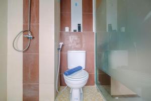 une salle de bain avec toilettes et douche en verre dans l'établissement Compact and Simple Studio Apartment at Saladdin Mansion By Travelio, à Parungmalela
