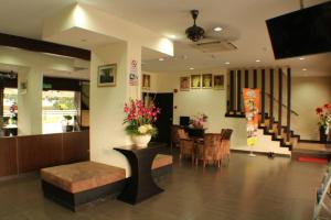 een lobby met een tafel met bloemen en een eetkamer bij D&F BOUTIQUE HOTEL SENAWANG in Senawang