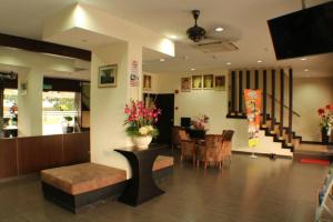 a lobby with a table with flowers and a dining room at D&F BOUTIQUE HOTEL SENAWANG in Senawang