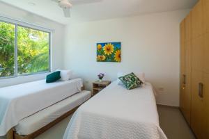 two beds in a room with a window at Magico Apartamento Frente al Mar 3 Habitaciones B21 in Coveñas