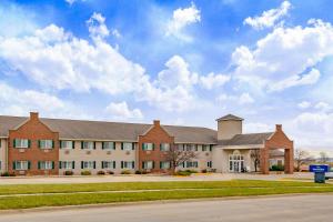 a large brick building with a sky at AmericInn by Wyndham Pella in Pella