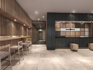 a lobby with a bar and chairs in a building at Smile Hotel Shin-osaka in Osaka