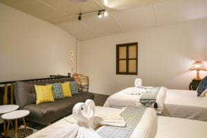 un soggiorno con 2 letti e un divano di ohana House-31 a Malacca