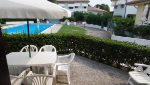 a table and chairs with an umbrella next to a pool at Villa Cà D'Oro in Duna Verde