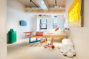 a bedroom with a bed and a table with a toy at Artist Hotel - BnA STUDIO Akihabara in Tokyo