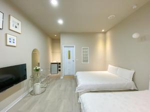 1 dormitorio con 2 camas y TV de pantalla plana en 羅東微風小棧民宿, en Luodong