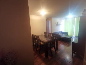 a dining room with a table and chairs and a couch at Departamento Central Familiar in Antofagasta