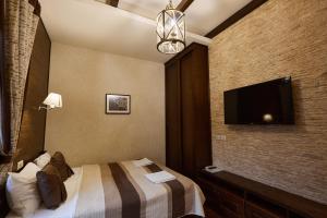 a hotel room with a bed and a flat screen tv at Petrani Central in Kyiv