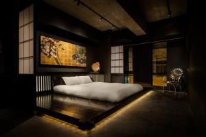 a bedroom with a large bed with a painting on the wall at Artist Hotel - BnA STUDIO Akihabara in Tokyo