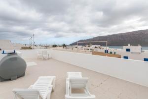 a balcony with white chairs and a view of the ocean at El Sombrerito 6 in Caleta de Sebo