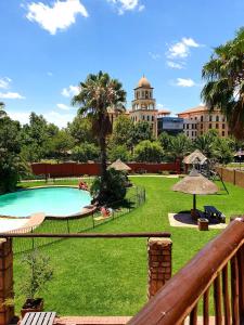 a view of a park with a pool and a building at Merry Monte Casino Lodge House in Fourways in Sandton