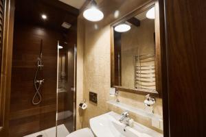 a bathroom with a shower, sink, and mirror at Petrani Central in Kyiv