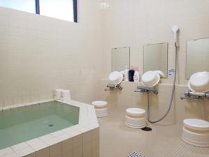 a bathroom with a tub and two toilets and a shower at Pilot Lodge in Hakuba