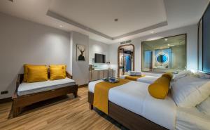 Graph Hotels Bangkok في بانكوك: غرفه فندقيه سريرين مع مخدات صفراء