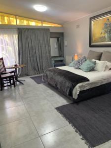 a bedroom with a large bed and a table at Rabbit Hole Hotel in Krugersdorp