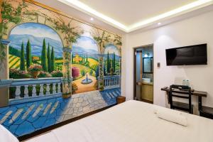 a bedroom with a painting on the wall at Lotus Laverne Hotel in Ho Chi Minh City