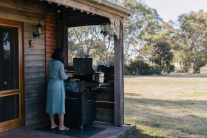 a woman standing in front of a stove at Grampians Historic Tobacco Kiln in Moutajup
