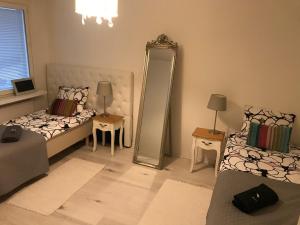 uma sala de estar com duas camas e um espelho em Tyylikäs rivitaloasunto Lohjalla em Lohja