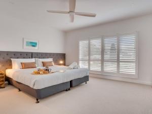 a bedroom with a large bed with a ceiling fan at Bella K in Kiama