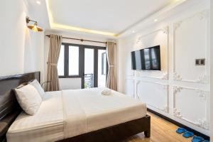 a bedroom with a bed and a tv and windows at Lotus Laverne Hotel in Ho Chi Minh City