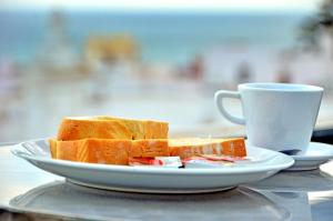 a plate of bread and a cup of coffee at Hostal Campito in Conil de la Frontera