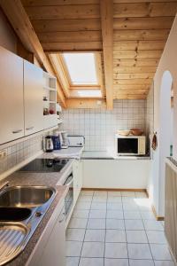 a kitchen with a sink and a microwave at Ferienwohnung Hofmann in Eggstätt