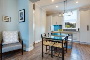 a kitchen and dining room with a glass table and chairs at City Retreat Hobart in Hobart