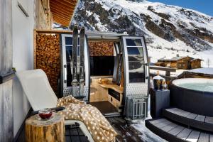 an rv with a tub and a snow covered mountain at Walserhuus Sertig in Sertig Döfli