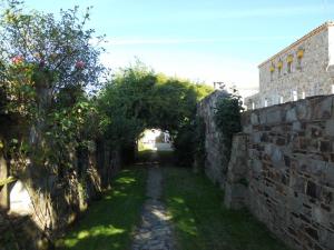 an alley with an archway next to a stone wall at Hotel Temple Pradorrey in Astorga