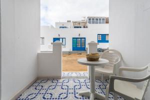 a table and chairs in a room with a view of a building at El Sombrerito 4 in Caleta de Sebo