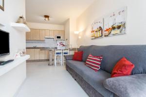 a living room with a gray couch and a kitchen at El Sombrerito 4 in Caleta de Sebo