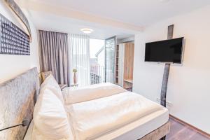 een hotelkamer met een bed en een flatscreen-tv bij Weinhotel Ayler Kupp in Ayl